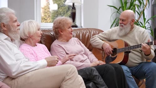 Seniors Relaxing, Playing Guitar Together on Sofa