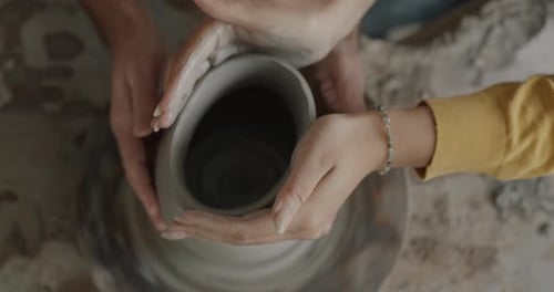Closeup of Male and Female Hands Making Pot Together While Couple Enjoying Pottery Class