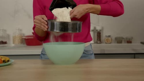 Woman Sifting Flour into Bowl for Baking