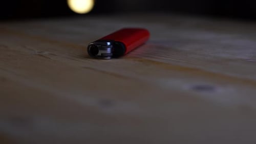 Red Lighter on Wooden Surface