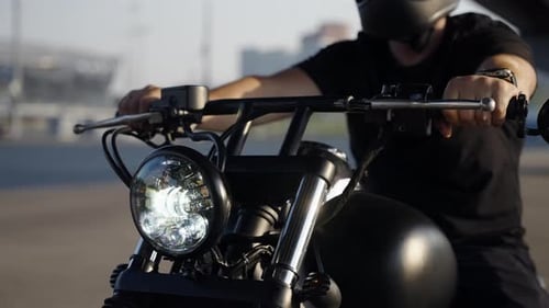 The Handlebars of a Black Bike A Man in a Black Protective Helmet Turns the Throttle Stick Brutal