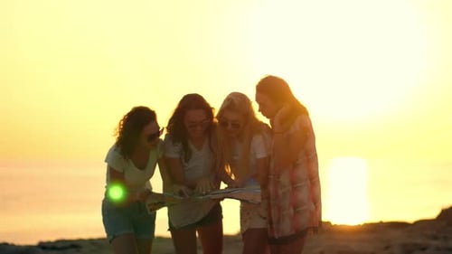 Chicas turistas mirando la guía. Mujer turista mirando el mapa en la orilla del mar
