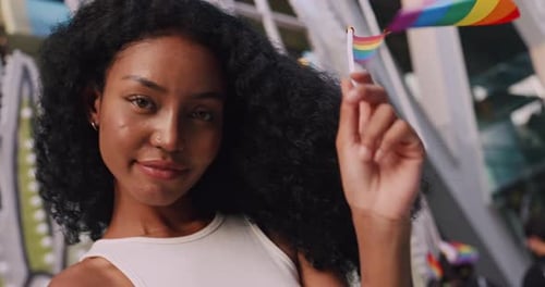 Woman Smiles with Pride Flag at Pride Celebration