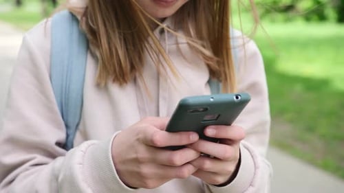Teen Using Smartphone in Green Nature Setting