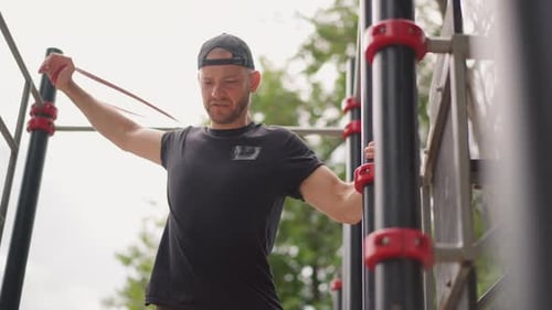 Person Exercising With Resistance Band Outdoors At Park Man Engaged In Mobility And Strength Workout