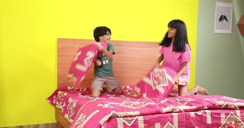 Boy and Girl Having a Pillow Fight on Bed