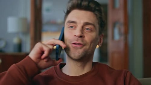 Smiling Man Talking on Phone at Home