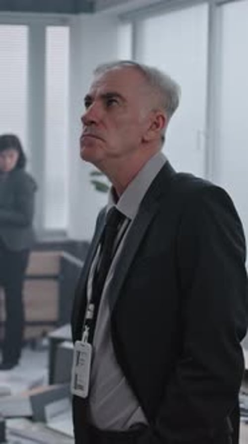 Serious Man in Suit Looks Up in Office