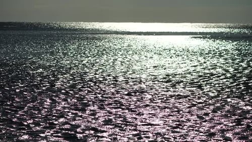 Abstrakte strahlende Sonnenreflexionen auf der blauen Oberfläche von Meereswellen
