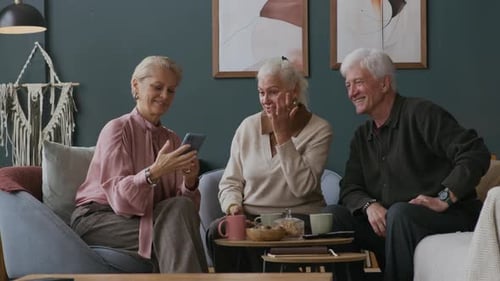 Senior Friends Chatting and Taking a Selfie Indoors