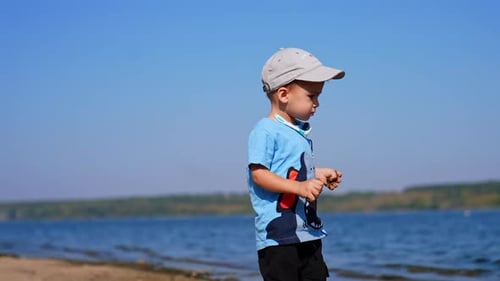 Small infant boy playing on a beach. Summer playing on sunny day.