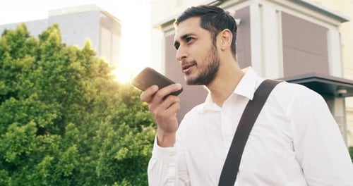 4k video footage of a handsome young businessman using a mobile phone in the city
