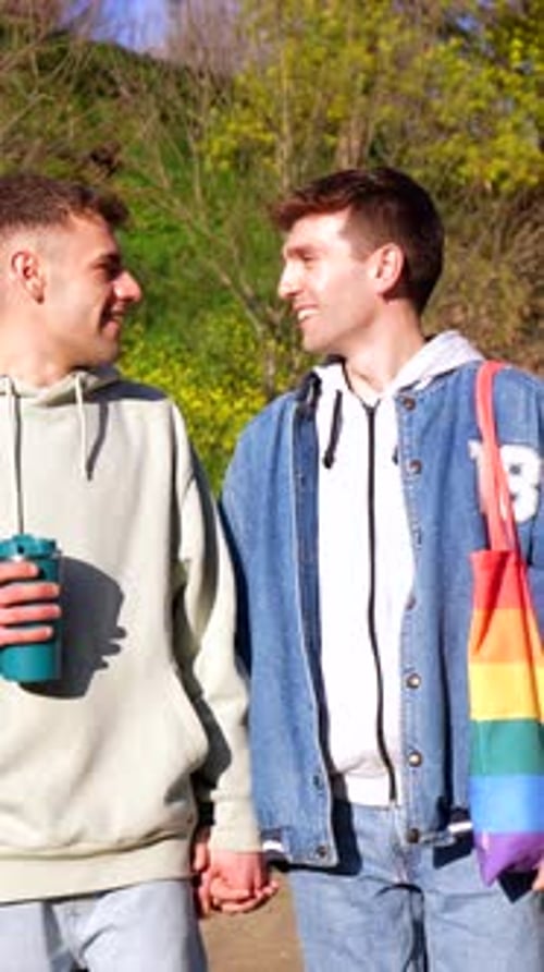 Young caucasian gay couple sharing intimate moments in a park