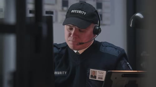 Security Guard Working at Desk with Computer