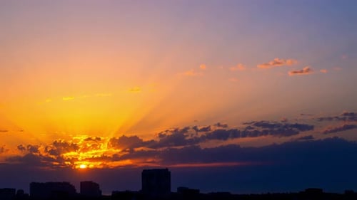 Sunrise from Clouds over City Rooftops