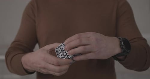 Man in Brown Clothes Solves Rubik Puzzle in Office Closeup