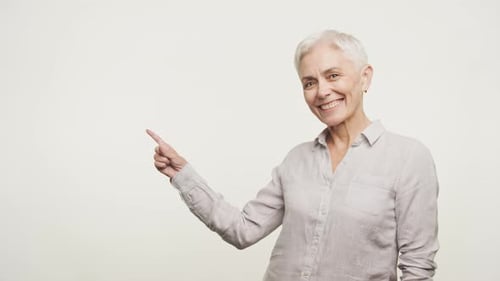 Senior Woman Point At Copy Space on White Background