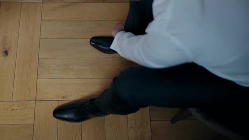 Man Lacing Up Black Dress Shoes Indoors