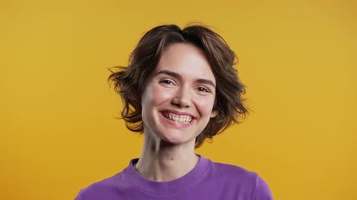 Smiling Woman With Short Hair Against Yellow Background