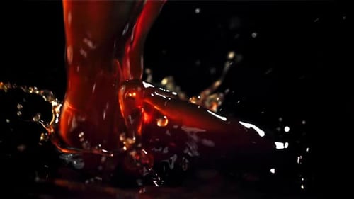 A Stream of Black Coffee with Splashes Filmed on a Highspeed Camera at 1000 Fps