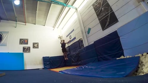 Athlete Performs Acrobatic Flips in Indoor Setting