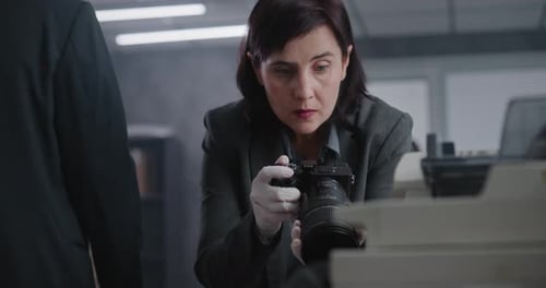 Woman Examining Camera at Investigation Scene