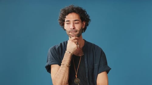 Pensive man thinking something, having good idea isolated on blue background in studio