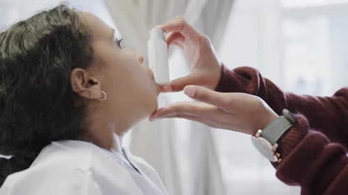 Biracial mother using inhaler on her daughter in hospital in slow motion