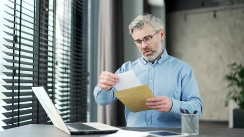 Man Reviews a Letter with a Concerned Expression