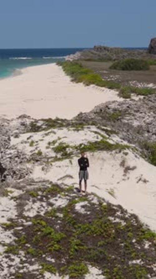 Man Stands on Beach Overlook on Sunny Day