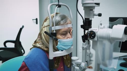 Ophthalmology specialist doing eye checkup for elderly woman