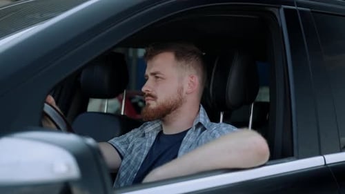 Man Inside Vehicle With Hand On Steering Wheel