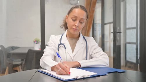 Une femme médecin multiraciale rédige un rapport médical à l'hôpital