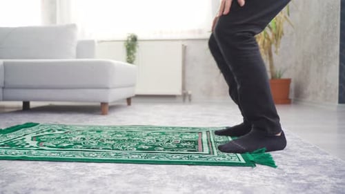 Man Kneeling in Prayer on Green Prayer Rug