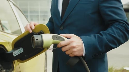 Unerkennbarer Mann steckt Stromanschluss in das EV-Auto