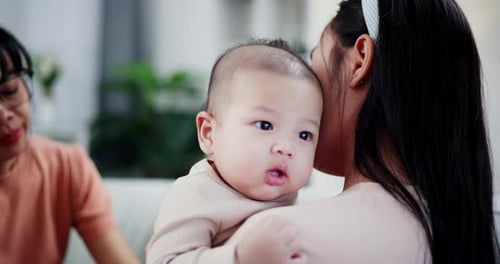 Loving Mother Holding Adorable Baby Indoors