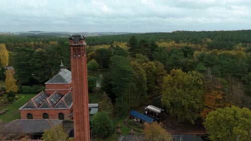 Atmospheric Aerial View of Victorian Pumping Station Encircled by Forest During Autumn in United