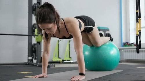 Woman Doing Core Exercise with Stability Ball in Gym