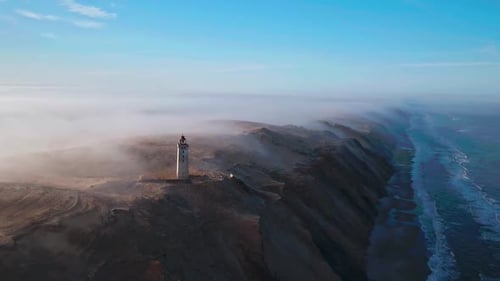 Lighthouse Rubjerg Knude Fyr in fog at the coast of Denmark in the morning