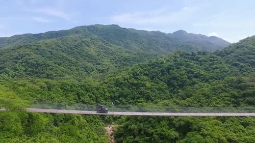 RZR Crossing Suspension Bridge with Mountain Backdrop
