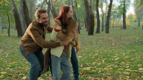Happy Family Laughing Together in Autumn Park