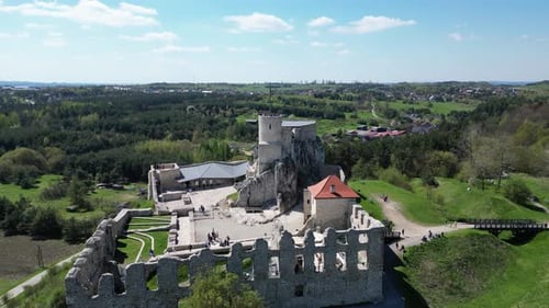 Medieval Rabsztyn castle with a tower, walls, and courtyard during a beautiful summer day surrounded