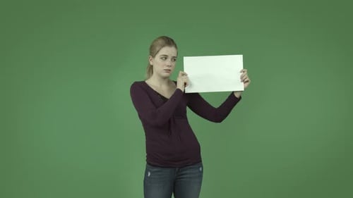 casual caucasian blond girl isolated on green upset worried with blank sign