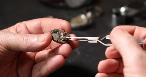 Close Up of Watchmaker Assembling Intricate Watch Mechanism