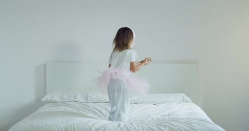 Girl Dancing on Bed with Headphones and Phone