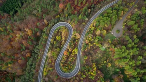 Carro e motocicleta dirigindo em uma maravilhosa estrada sinuosa nas montanhas cercadas por uma bela au