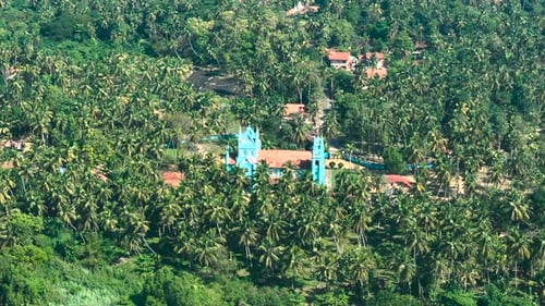 Aerial view of church, palm trees, lush forest, Sri Lanka.