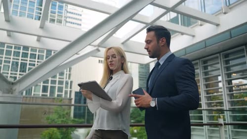 Business Professionals Collaborate on Tablet in Urban Setting