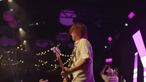 Musicians are Performing on Stage in Contemporary Musical Hall Guitar Bass and Drum Players and