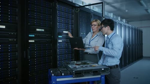 In the Modern Data Center: Engineer and IT Specialist Work with Server Racks, on a Pushcart Equipme